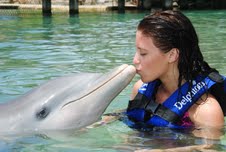 Cassi kisses a dolphin at Xcaret